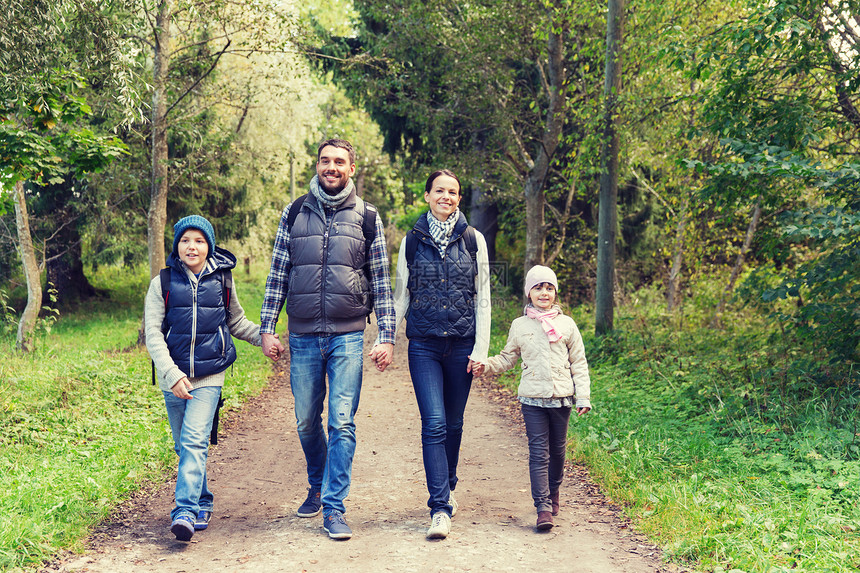 冒险,旅行,旅游,徒步旅行人们的快乐的家庭步行与背包森林快乐的家庭带着背包树林里远足图片