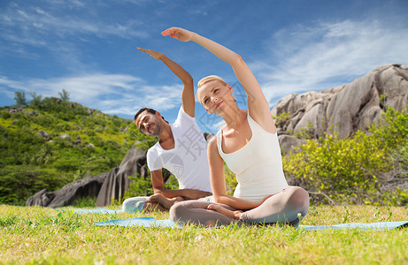 瑜伽,健身,运动人的微笑夫妇运动坐垫子户外微笑的夫妇户外瑜伽练图片