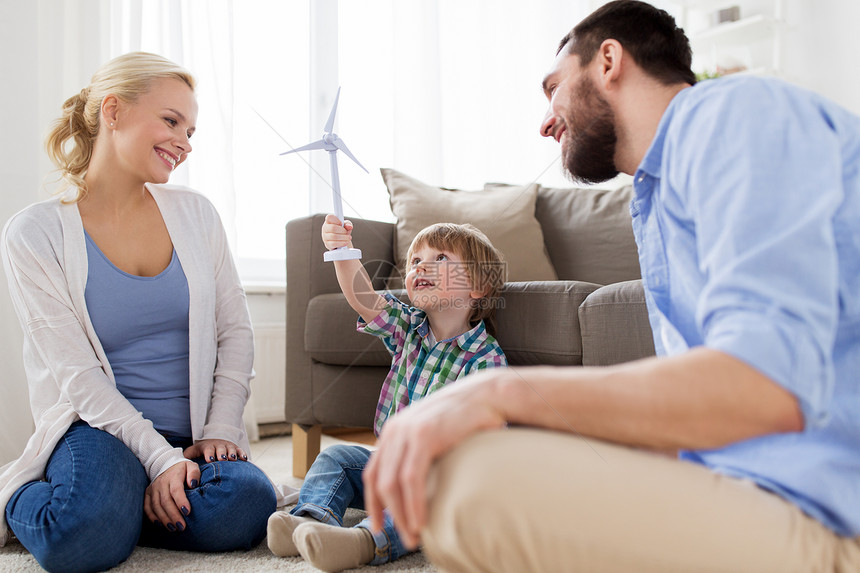家庭,可再生能源,生态人的快乐的小男孩父母家里玩玩具风力涡轮机快乐的家庭玩玩具风力涡轮机图片