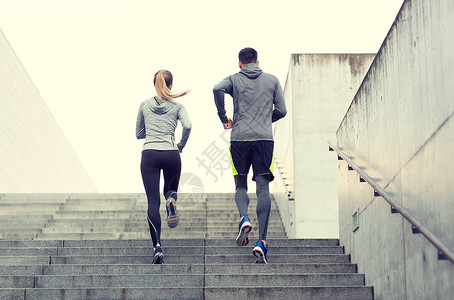 健身,运动,人,锻炼生活方式的夫妇跑楼上的城市楼梯夫妇城市楼梯上跑上楼背景图片