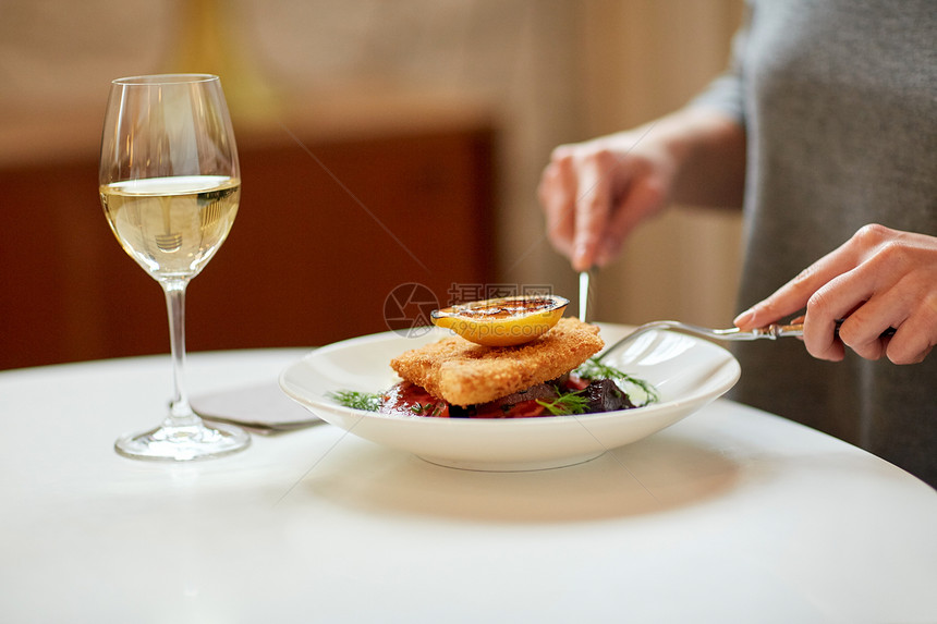 食物,新北欧美食人们的女人吃包鱼片与烤箱烤甜菜根番茄沙拉与叉子刀咖啡馆餐馆女人咖啡馆餐馆吃鱼沙拉图片