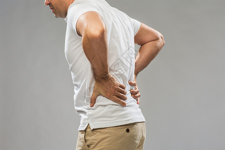 腰肾人,医疗保健问题密切的人遭受痛苦的背部灰色背景特写患背痛的人背景
