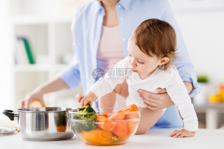 家庭,食物,健康饮食,烹饪人的快乐的母亲小女婴与蔬菜锅家里厨房快乐的母亲婴儿家煮蔬菜图片