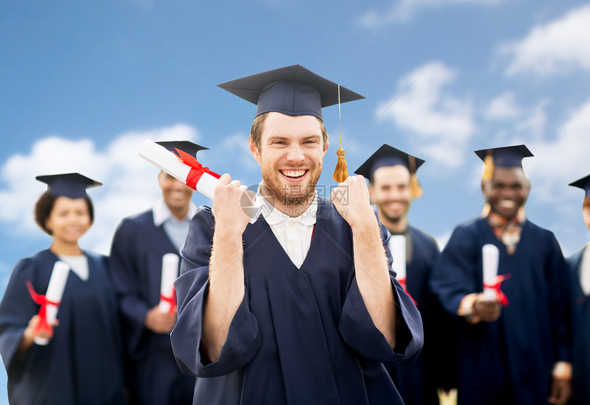 教育手势人的群快乐的国际学生穿着灰浆板学士服,毕业证书蓝天云层背景下庆祝成功毕业带着文凭庆祝毕业的快乐学生图片