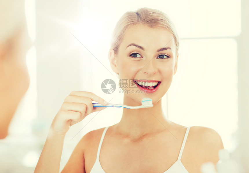 保健,牙科卫生,人与美的微笑的轻妇女牙刷,清洁牙齿,并家里的浴室看镜子牙刷的女人浴室刷牙牙刷的女人浴室图片