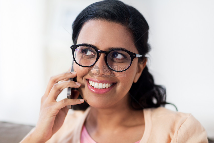 人,技术,沟通休闲快乐的微笑轻印度妇女戴着眼镜,家里打电话给智能手机快乐的印度女人家里打电话给智能手机快乐图片