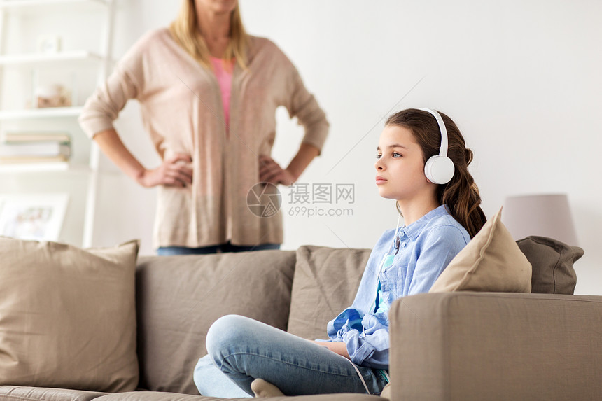 人,问题家庭观念女孩戴着耳机坐沙发上,母亲家里生气带耳机的女孩愤怒的母亲家带耳机的女孩愤怒的母亲家图片
