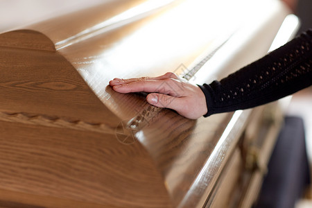 人们哀悼的妇女教堂葬礼上把手放棺材盖上教堂葬礼上,女人把手放棺材盖上图片
