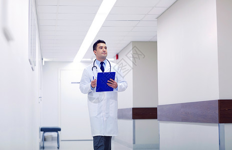 诊所,人,保健医学医生与剪贴板步行沿医院走廊医生带着剪贴板沿着医院走图片