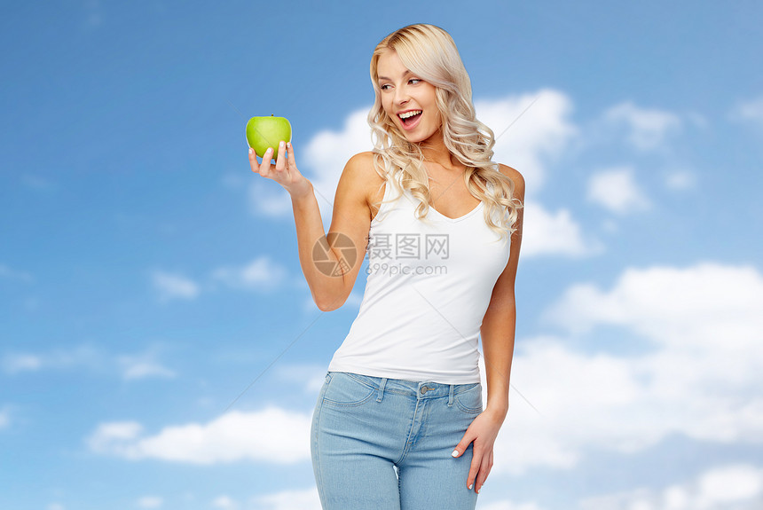 健康的饮食,饮食人的快乐的美丽的轻女人,绿色的苹果蓝天云彩的背景快乐的轻女人,绿色的苹果蓝天上图片