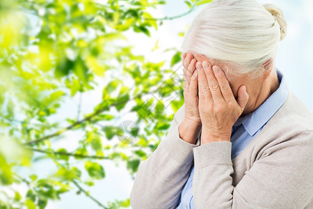 压力,龄人的老妇女患头痛悲伤的绿色自然背景患头痛悲伤的老妇女图片