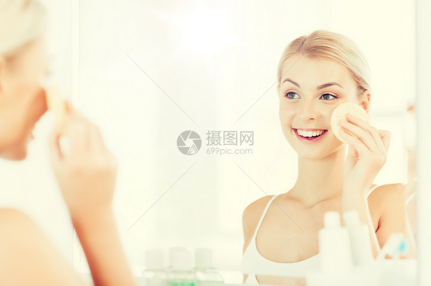 美容,护肤人的微笑的轻女人洗她的脸与部清洁海绵浴室轻女子浴室用海绵洗脸图片