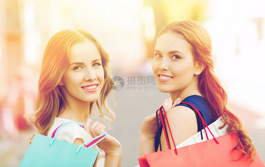 销售,消费主义人的快乐的轻妇女带着购物袋走城市街道上快乐的女人带着购物袋城市里散步图片