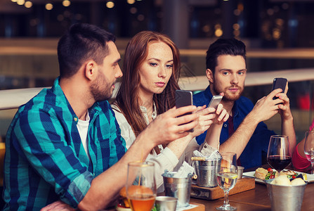休闲,技术,生活方式人们的朋友与智能手机餐厅就餐智能手机的朋友餐厅用餐图片