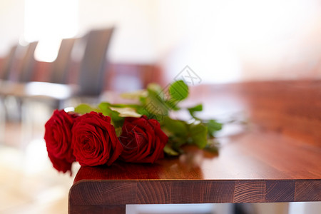 葬礼哀悼教堂长凳上的红玫瑰教堂葬礼上长凳上的红玫瑰背景图片