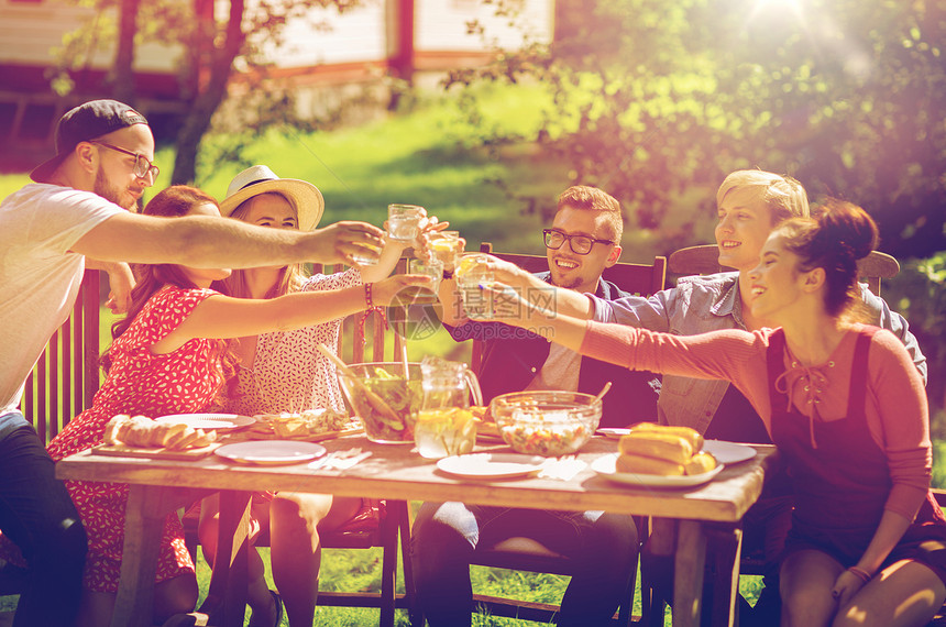 休闲,假期,饮食,人食物的快乐的朋友碰杯庆祝夏季花园聚会快乐的朋友们夏天的花园聚会上吃晚饭图片