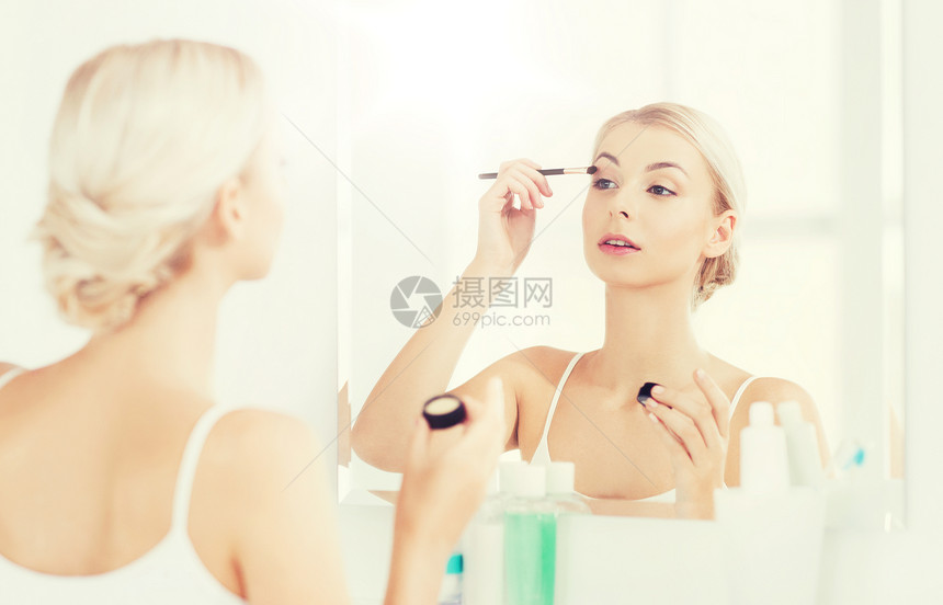 美容,化妆,化妆品,早晨人的轻的女人用化妆刷涂眼影,家里的浴室照镜子浴室里化妆刷眼罩的女人图片