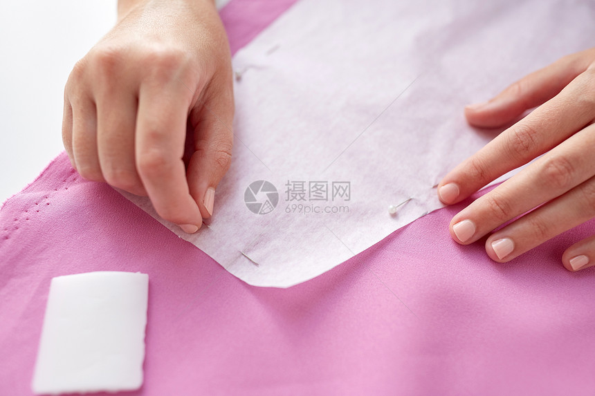 人,针线活裁剪裁缝妇女与针缝纸图案物缝纫工作室女人用别针把纸图案缝布料上图片