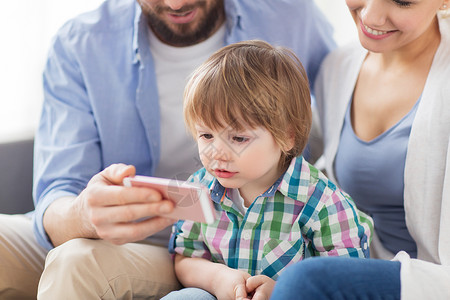 家庭,技术人的快乐的母亲,父亲小男孩家里智能手机家里智能手机的幸福家庭图片