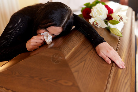 人们哀悼的教堂的葬礼上带着棺材的哭泣的女人棺材的女人教堂的葬礼上哭背景图片