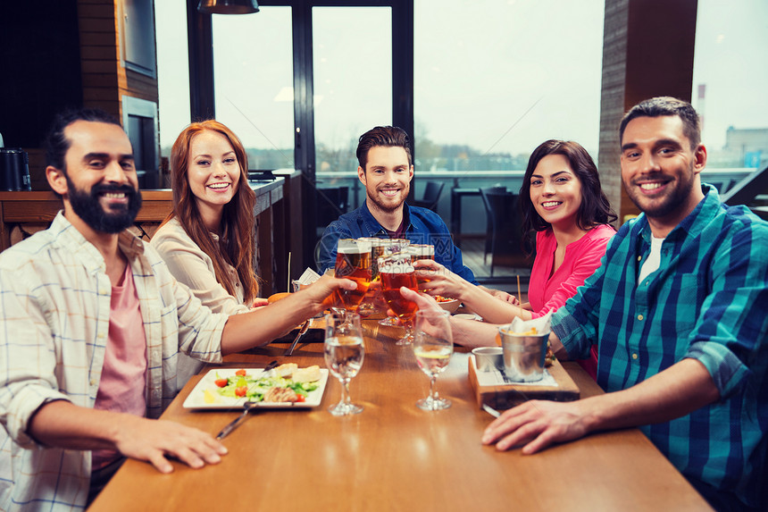 休闲,饮食,食物饮料,人假日的微笑的朋友餐馆酒吧吃晚餐喝啤酒朋友们餐馆吃饭喝啤酒图片