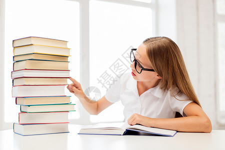 教育,学校人的学生女孩戴着眼镜,桌上坐着堆书学校戴眼镜带书的学生女孩图片