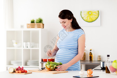 孕妇在厨房煮蔬菜沙拉图片