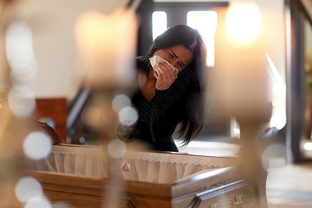 人们哀悼的教堂的葬礼上带着棺材的哭泣的女人棺材的女人教堂的葬礼上哭背景图片
