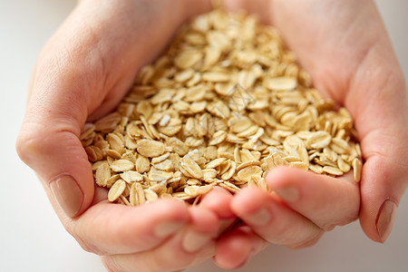 食物,健康的饮食人们的近距离的手燕麦片紧握着燕麦片的手背景图片