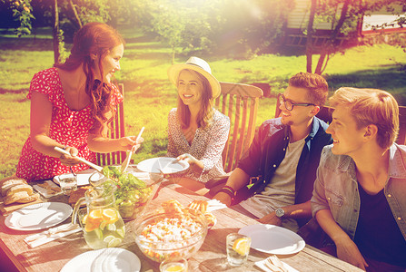 休闲,假期,饮食,人食物的快乐的朋友夏天的花园聚会上吃晚饭分享沙拉快乐的朋友们夏天的花园聚会上吃晚饭背景图片