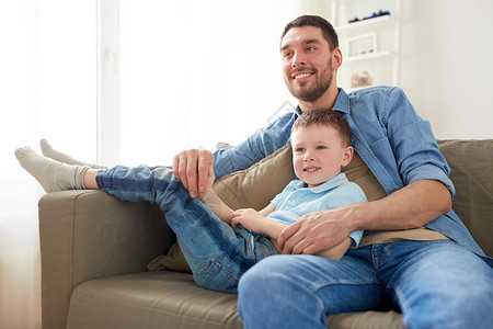 家庭,童,父亲人的快乐的父亲小儿子坐家里的沙发上幸福的父子坐家里的沙发上图片