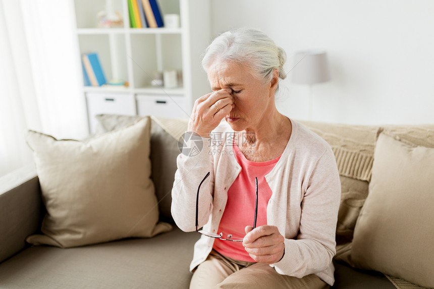 老,健康问题,视力人的老妇女戴着眼镜坐沙发上,家头痛戴眼镜的老妇女家头痛图片