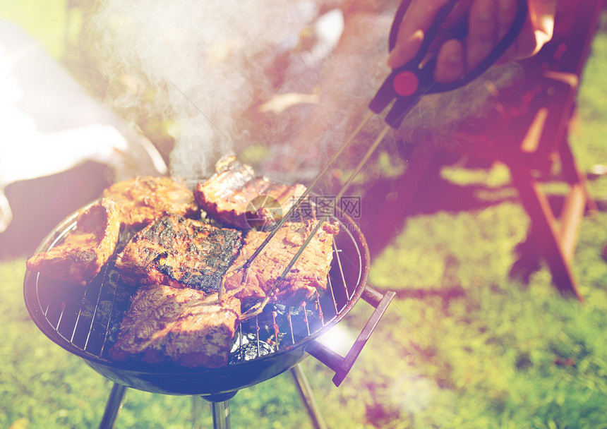 休闲,食物,人假日男子烹饪肉烧烤烧烤户外夏季聚会夏天的聚会上,男人烧烤架上煮肉图片