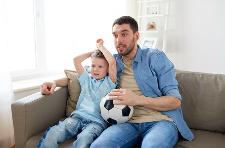 家庭娱乐活动体育人的父亲小儿子家看球赛足球电视父子家里看电视上的足球图片