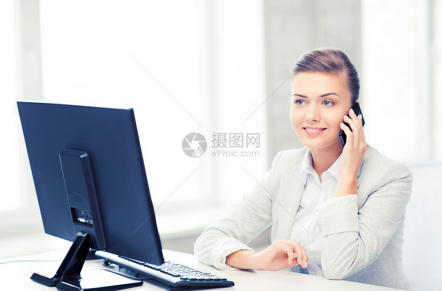 办公室里智能手机的微笑女商人的照片办公室里智能手机的女商人图片