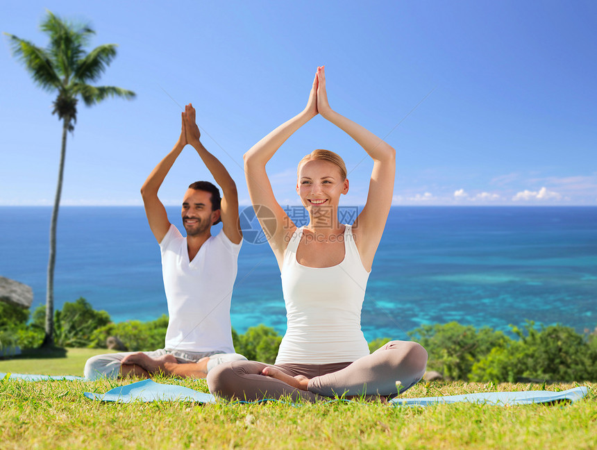健身,运动,瑜伽人们的快乐的夫妇冥想莲花姿态户外异国情调的自然背景与棕榈树海洋夫妇户外莲花姿势的瑜伽图片