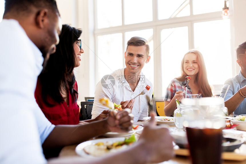 休闲,食物人的群快乐的国际朋友餐厅的餐桌上吃饭交谈快乐的朋友餐馆吃饭说话图片