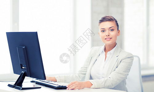 微笑的女商人办公室里电脑的照片办公室里电脑的女商人图片