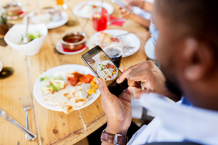 技术,饮食人的手与智能手机拍照食物餐厅手智能手机想象餐厅的食物图片