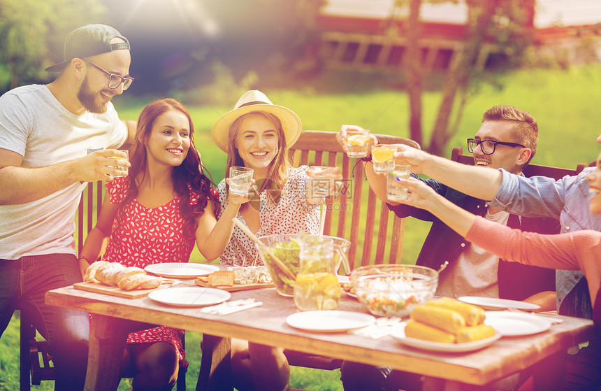 休闲,假期,饮食,人食物的快乐的朋友碰杯庆祝夏季花园聚会快乐的朋友们夏天的花园聚会上吃晚饭图片