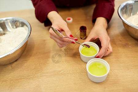 烹饪,烘焙人的厨师的手添加食物颜色与鸡蛋清碗厨师用蛋清把食物颜色加碗里背景图片