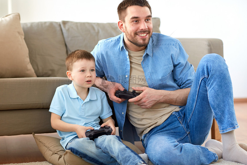 家庭,父亲人的快乐的父亲小儿子与游戏垫家里玩电子游戏父子家里玩电子游戏图片