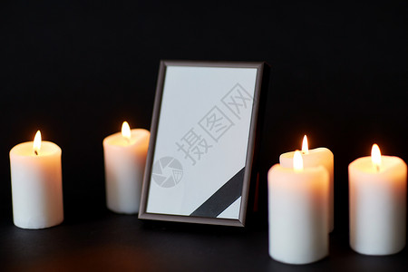 葬礼哀悼空相框与丝带燃烧蜡烛黑色背景葬礼上相框蜡烛上的黑色丝带图片