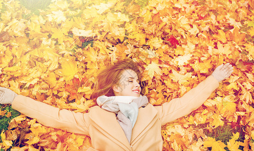 季节人的美丽的轻女人躺地上秋天的叶子上美丽快乐的女人躺秋叶上图片