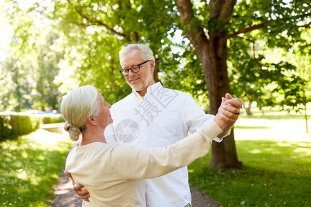 老,关系人的快乐的老夫妇夏季城市公园跳华尔兹快乐的老夫妇夏季城市公园跳舞背景图片