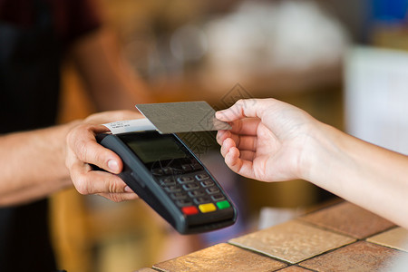 信用监管现代技术人的男人酒保与支付终端客户的手与信用卡咖啡厅酒吧手支付终端信用卡背景