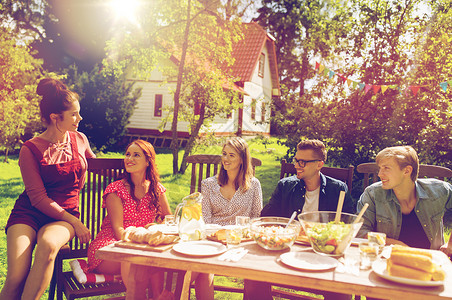 休闲,假期,沟通,人食物的快乐的朋友夏季花园聚会上吃晚饭快乐的朋友们夏天的花园聚会上吃晚饭背景图片