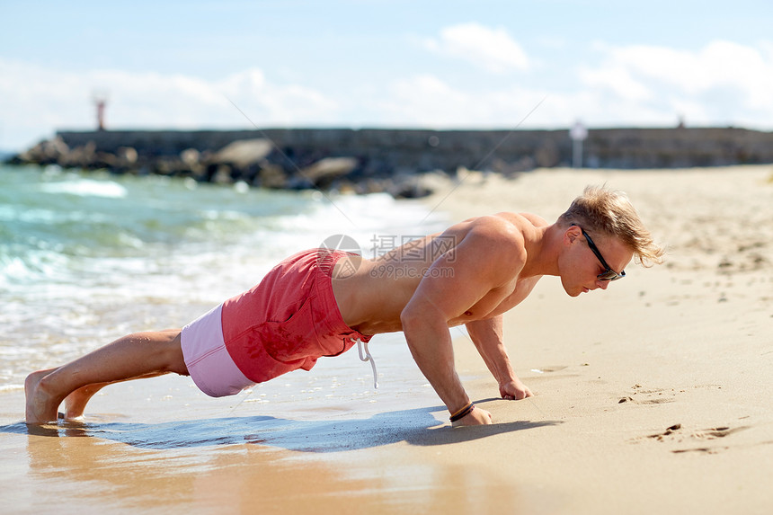 运动,健身人的快乐的轻人太阳镜锻炼俯卧撑夏季海滩轻人夏天的海滩上俯卧撑图片