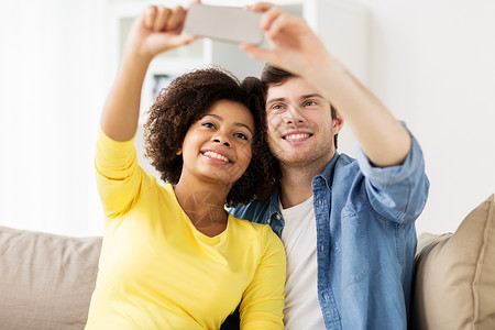 家庭,技术人的幸福的夫妇与智能手机家里自拍幸福的夫妇与智能手机家里自拍图片