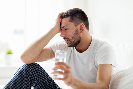 人,睡觉时间休息的男人床上喝杯水家家里杯水躺床上的男人图片